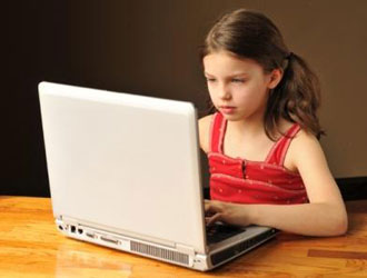 Девочка за ноутбуком играет в онлайн игры